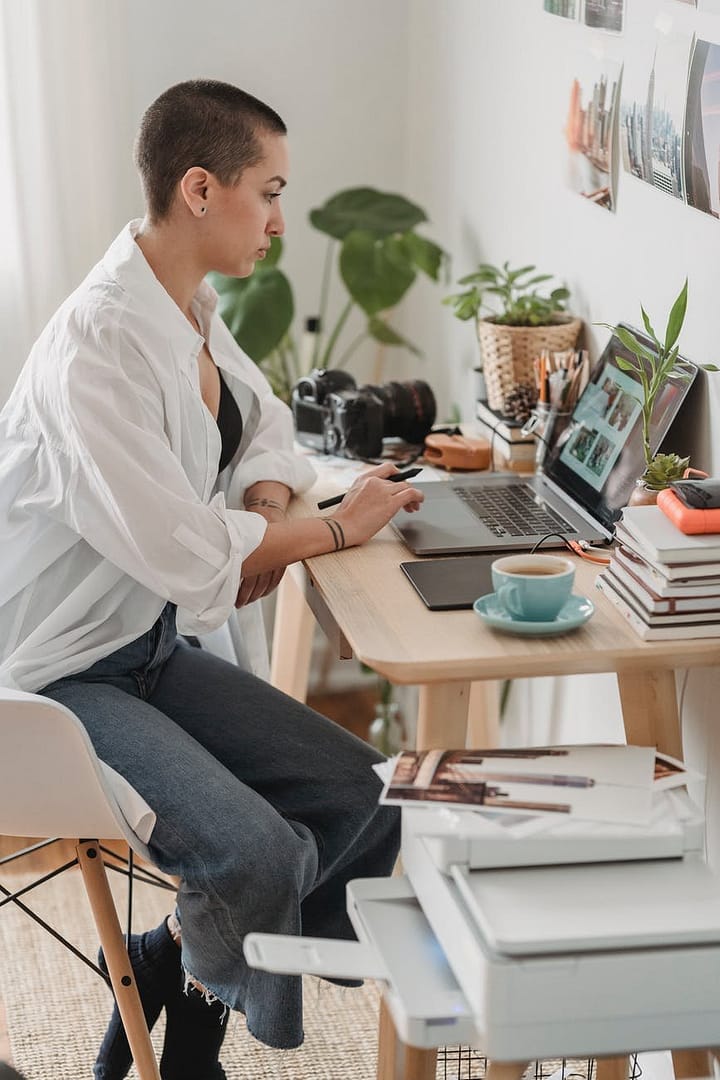 focused female freelancer editing photos on laptop